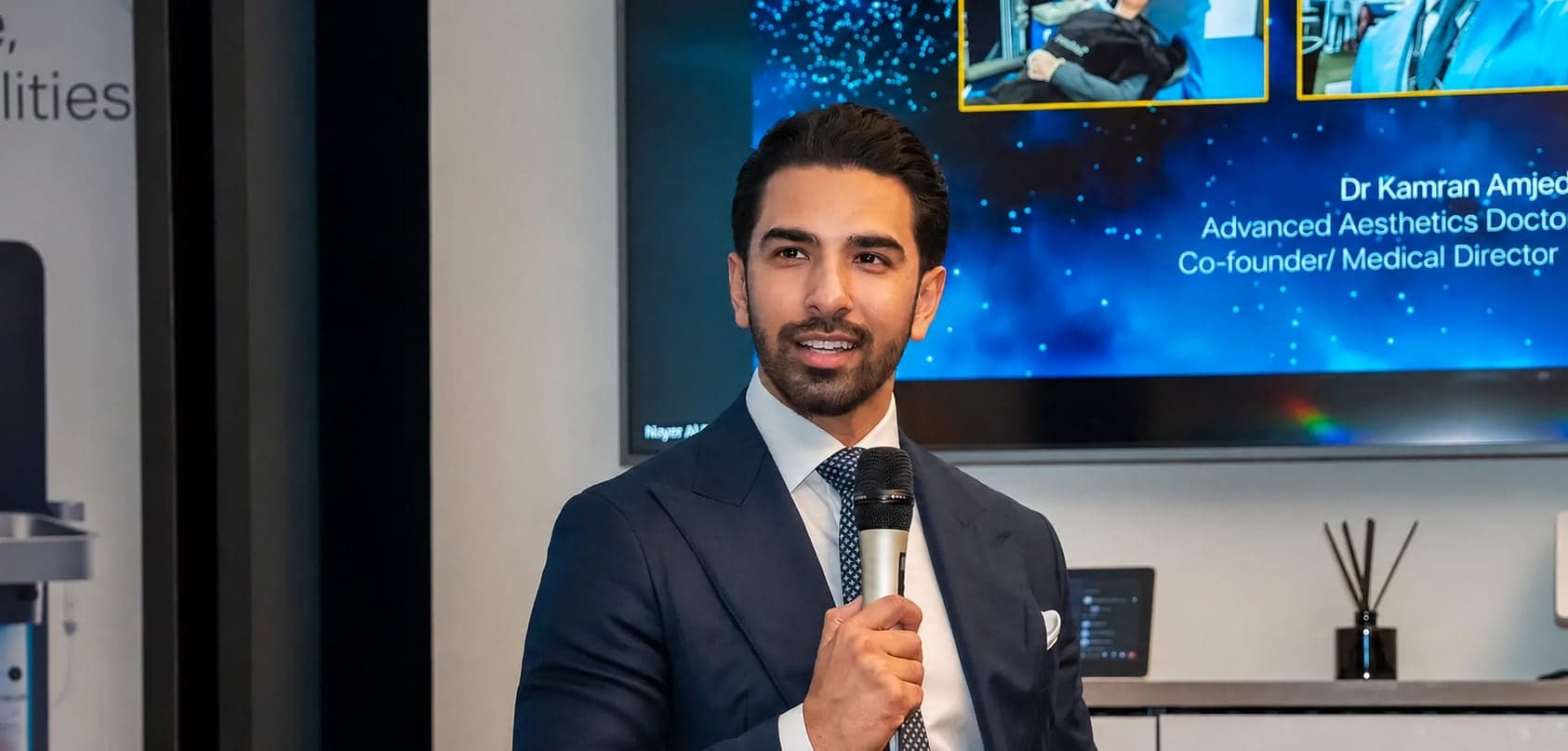 Dr Kamran Amjed speaking with a microphone at a clinical education event